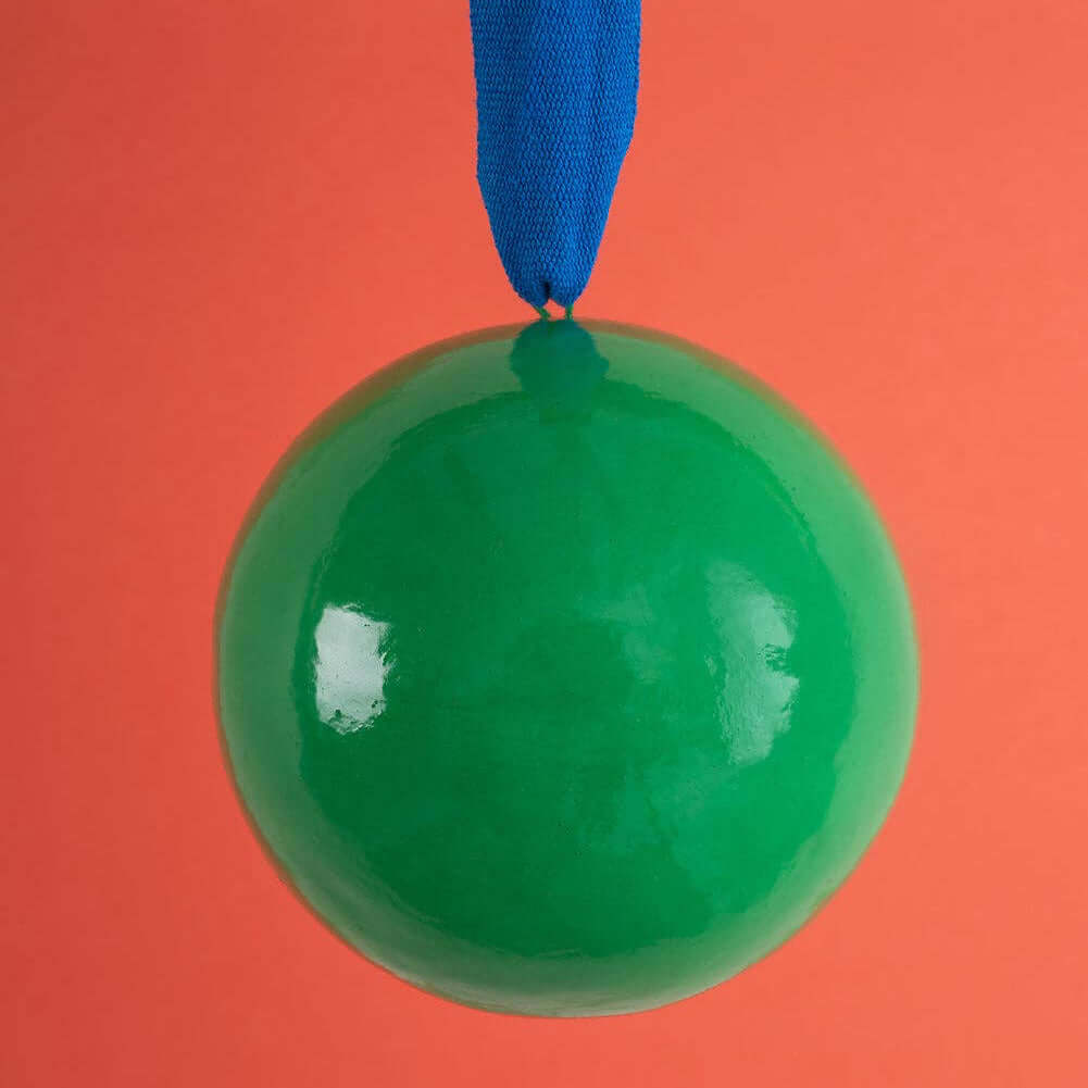 Green ball with a blue ribbon on an orange background