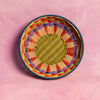 Woven bowl with multicolored pattern on a pink background