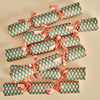 Set of Christmas crackers with green and red pattern and pink ribbons on a beige background