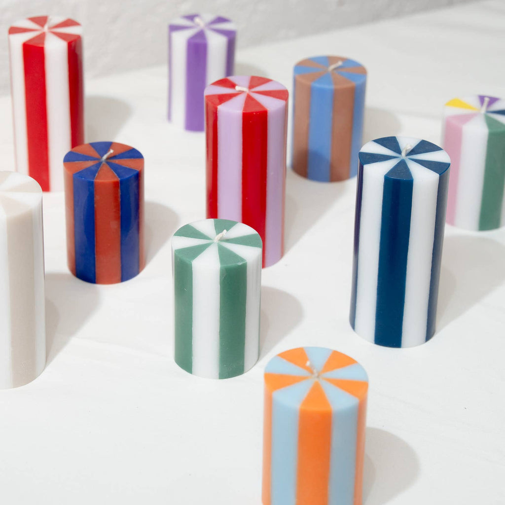Colorful cylindrical candles on a white surface