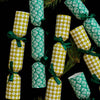 Green and white patterned cracker decorations on a dark background with pine branches.