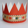 Red and white paper crown with a decorative band on a light gray background