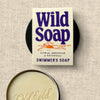 Wild Soap packaging with a bar of soap on a textured beige background