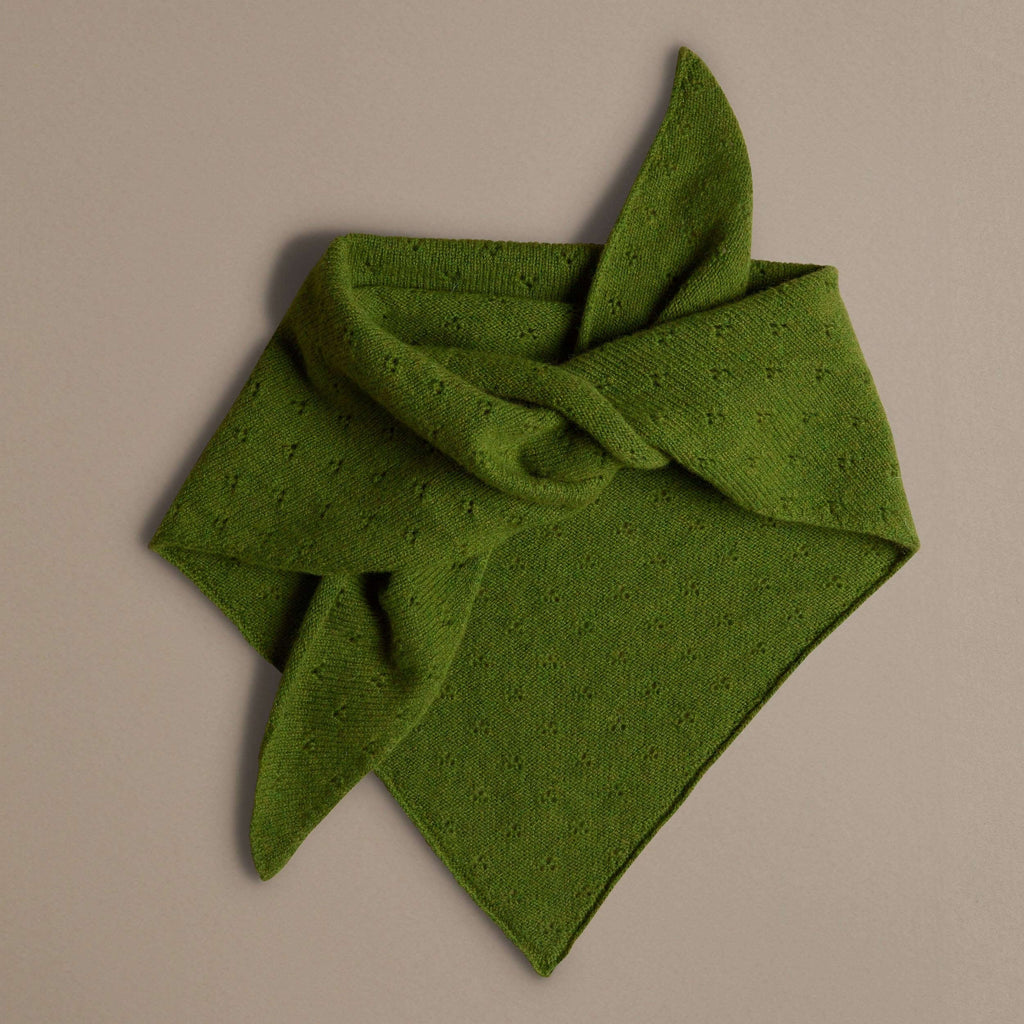 Green knitted scarf on a beige background