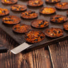 Baked crackers on a baking tray with a spatula on a wooden surface