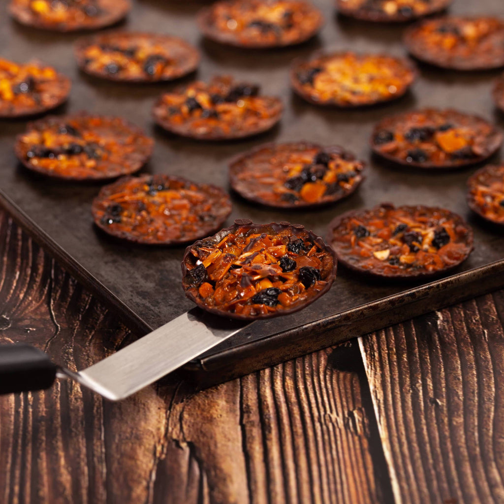 Baked crackers on a baking tray with a spatula on a wooden surface