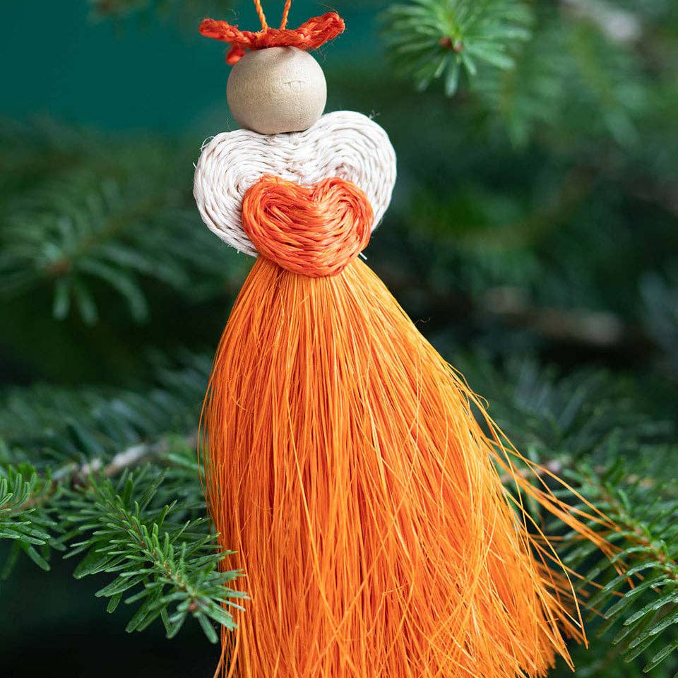 Decorative tassel ornament hanging on a branch with a blurred green background