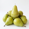 A novelty candle shaped like a pear, styled with several real pears around it on a clean white background.