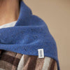 Blue scarf with a patterned edge and 'Rove' label on a beige background