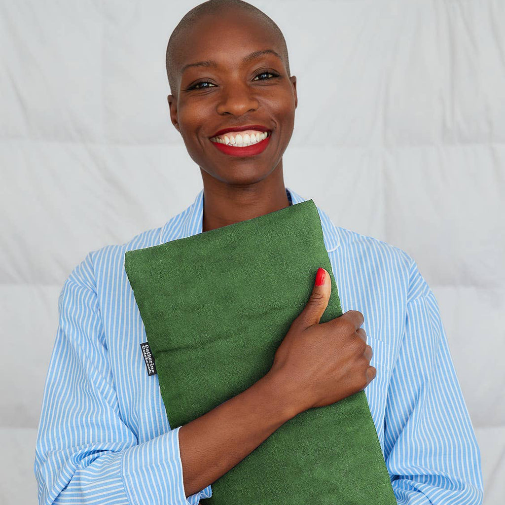 Person holding a green clutch against a plain background