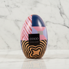 Colorful chocolate egg with geometric patterns on a pink background, featuring the brand 'Coco'.