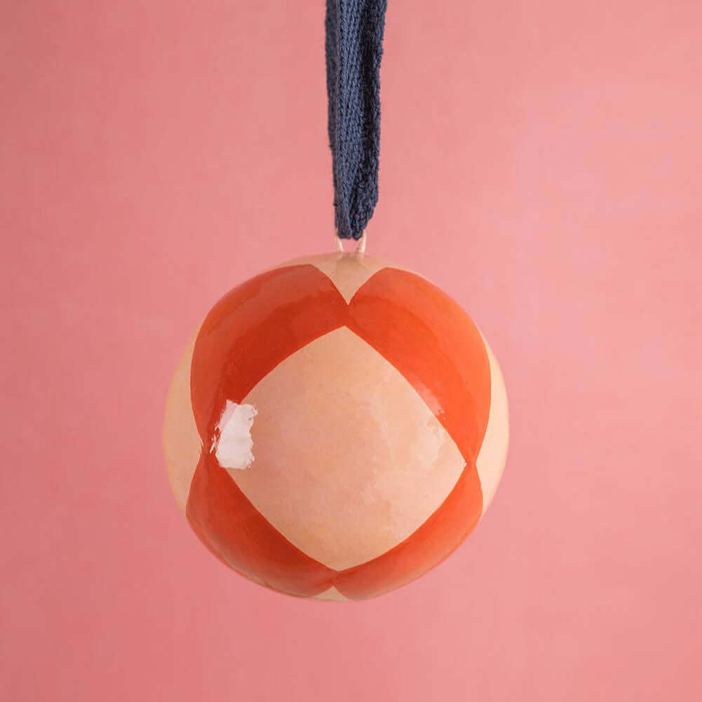 Decorative ornament with a geometric design on a pink background