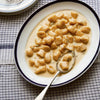 Plate of gnocchi with a creamy sauce on a checkered tablecloth