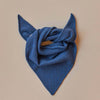 Blue fabric folded into a triangle shape on a beige background