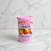 A pink plastic container of Chiaverini Confetturi Extra Ciliegie (cherry puff pastry) on a light gray background.