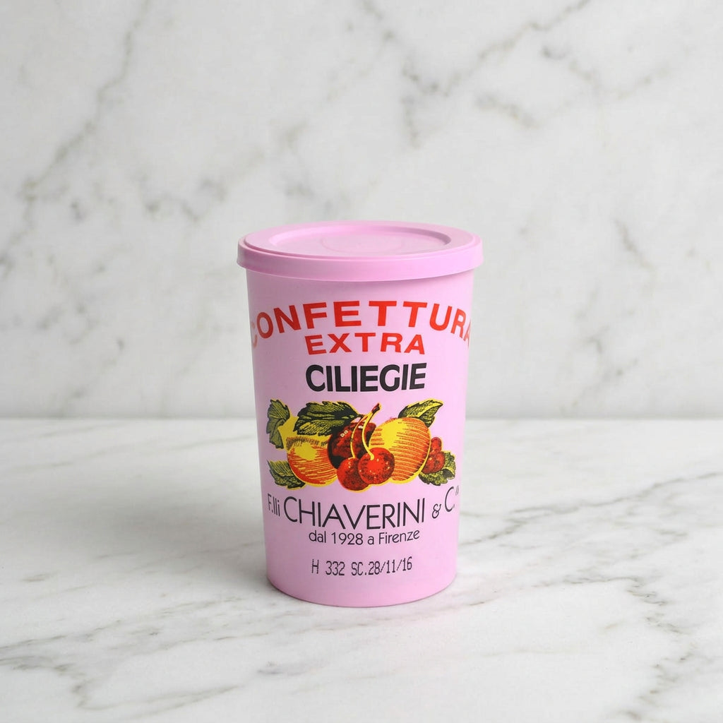 A pink plastic container of Chiaverini Confetturi Extra Ciliegie (cherry puff pastry) on a light gray background.