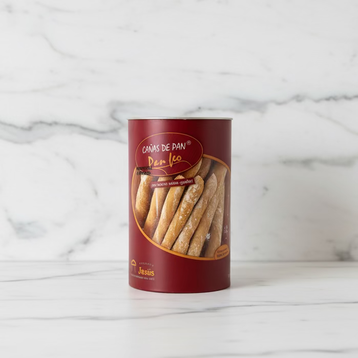 Container of bread sticks on a wooden surface with floral wallpaper in the background