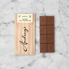 Audrey's salted milk chocolate bar with packaging on a light gray background