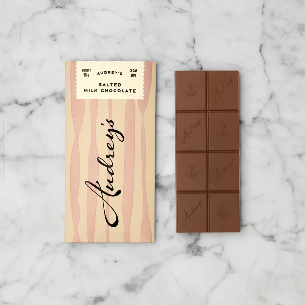 Audrey's salted milk chocolate bar with packaging on a light gray background
