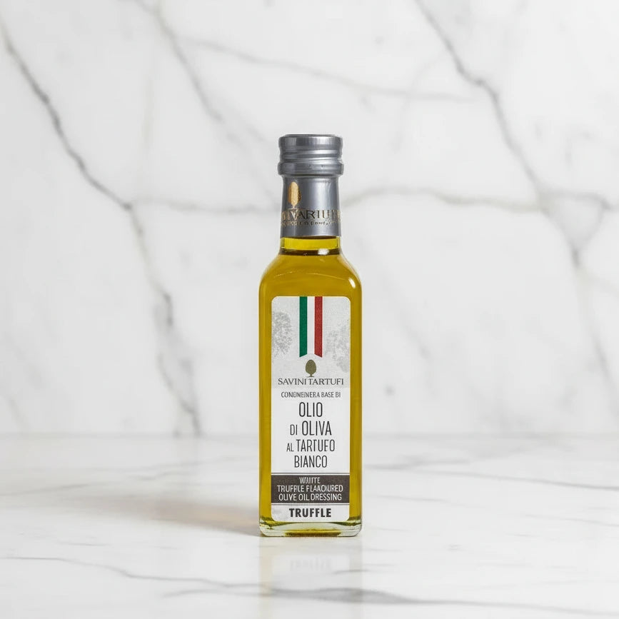 Bottle of truffle olive oil on a wooden block with a vintage scooter in the background