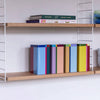 Shelves with books, lemons, and kitchen items against a white wall