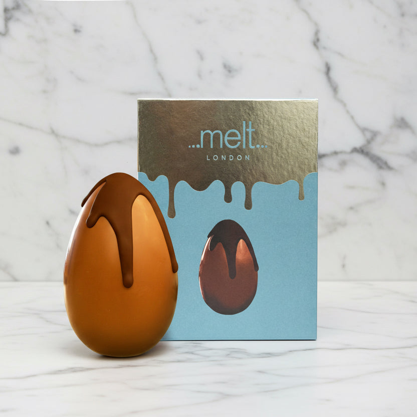 A milk chocolate Easter egg with sea salt, next to its packaging that reads '...melt... London'.