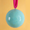 Turquoise ball with a pink ribbon on a yellow background