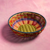 Colorful woven basket on a pink background