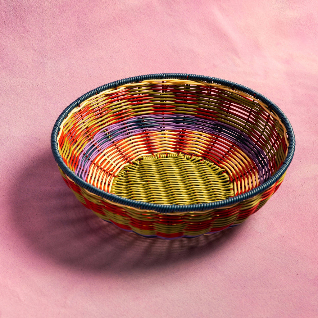 Colorful woven basket on a pink background
