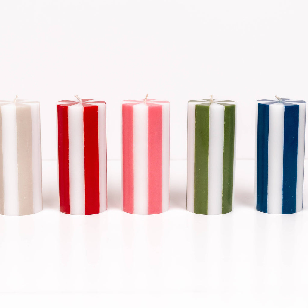 Five vertical candles in different colors arranged on a white background