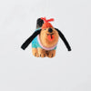 A felt dog hanging ornament with a turquoise sweater, pink collar, black ears, and an orange-red bow on its head, suspended by a white string against a light gray background.