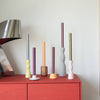 Collection of colorful vases on a red surface with a white wall background