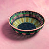 Woven basket with multicolor pattern on a pink background