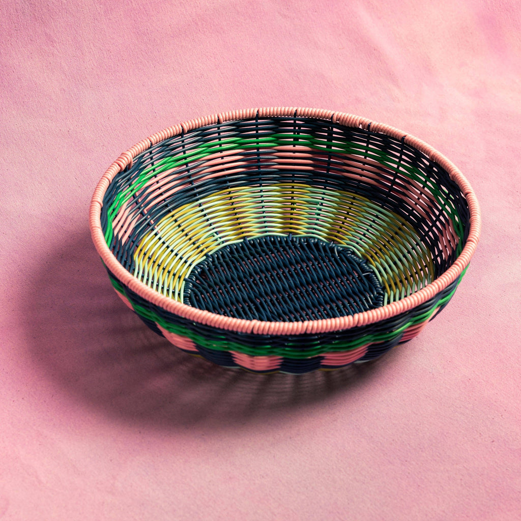 Woven basket with multicolor pattern on a pink background