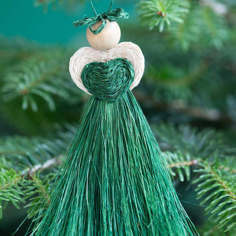 Green tassel ornament hanging on a tree branch