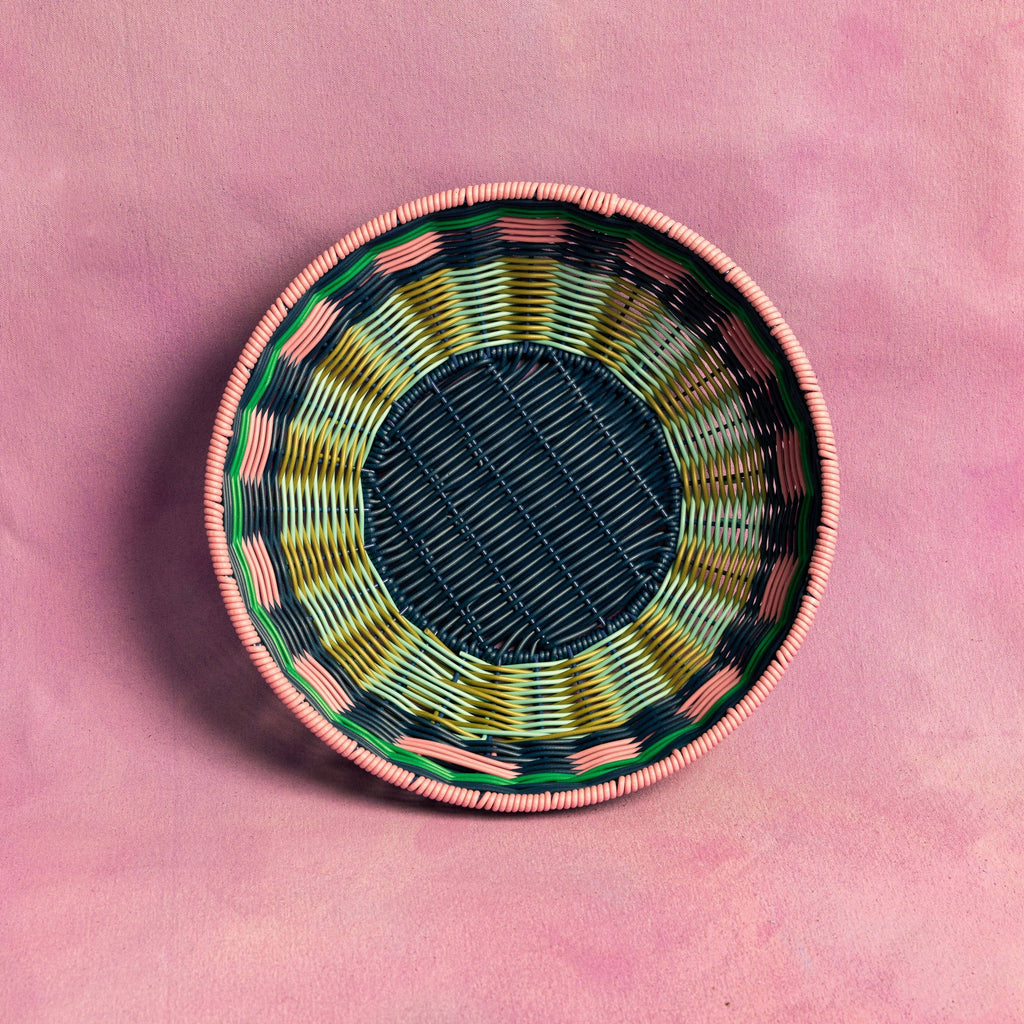 Woven basket with colorful patterns on a pink background