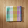 Checkered fabric napkin with pastel colors on a white background