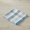 Folded checkered fabric napkin with blue, white, and gray plaid pattern on a white background