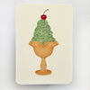 Notebook with a design of a green ice cream cone with a cherry on top on a beige background