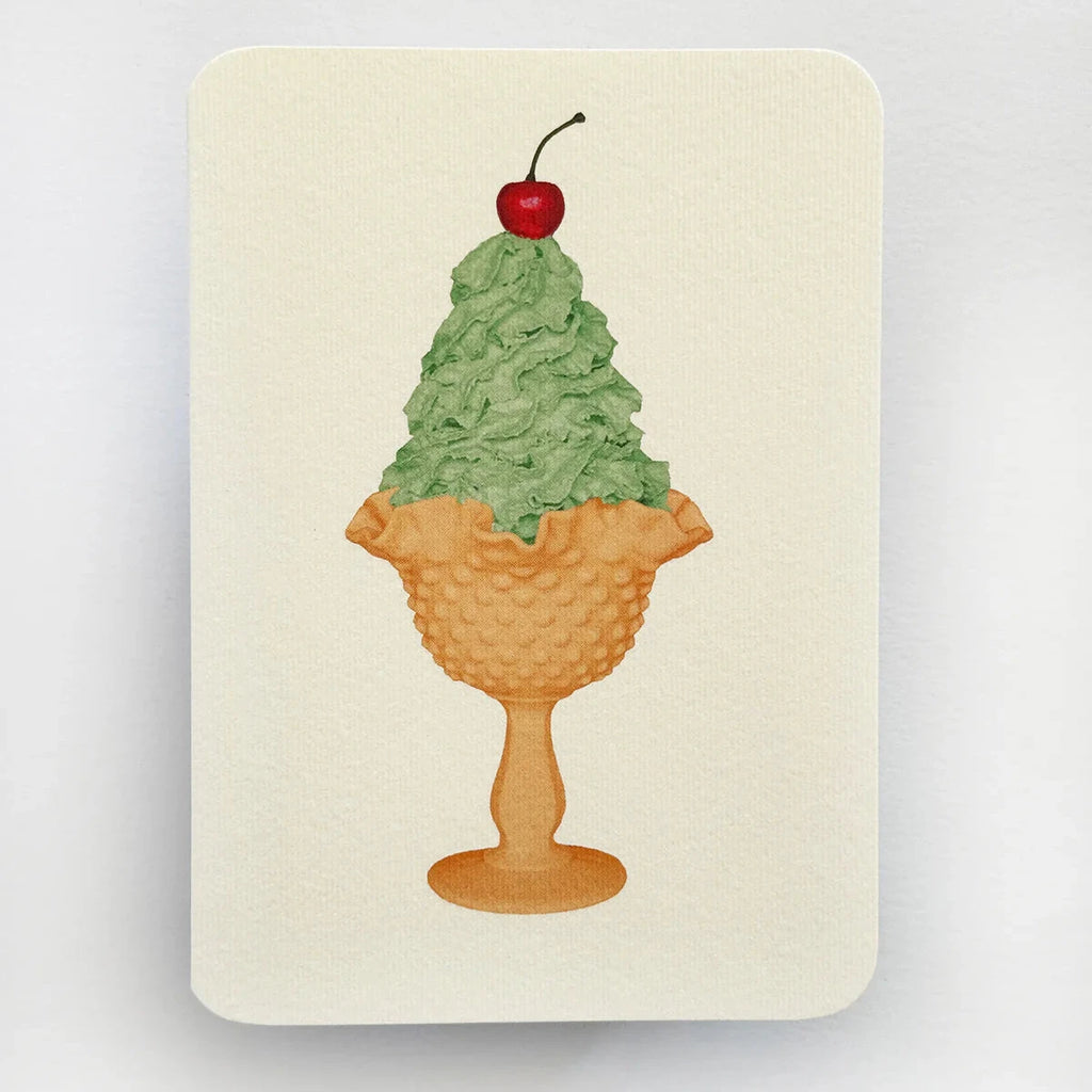 Notebook with a design of a green ice cream cone with a cherry on top on a beige background